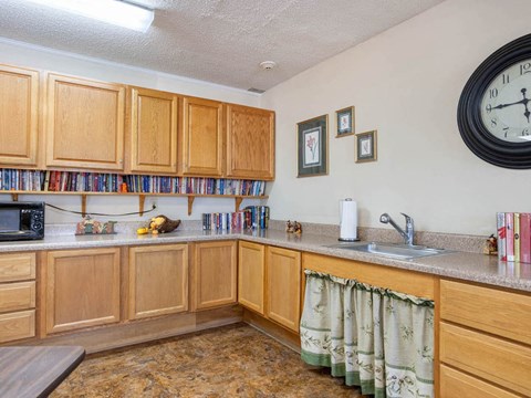 a kitchen with wooden cabinets and a large clock