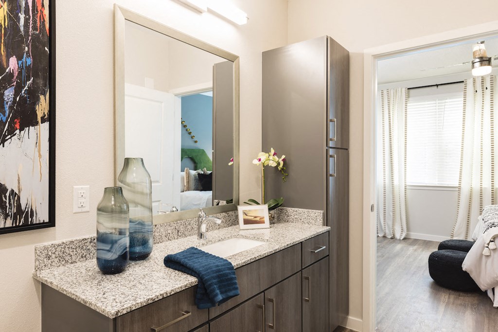 Modern bathroom with granite and ample cabinetry at Residences at The Green in Lakewood Ranch, FL