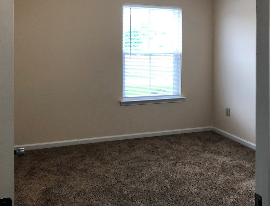 spacious bedroom with plush carpeting