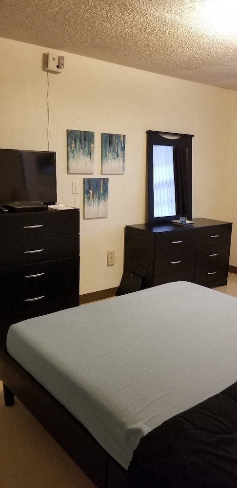 bedroom with overhead lighting, window, and model furnishings