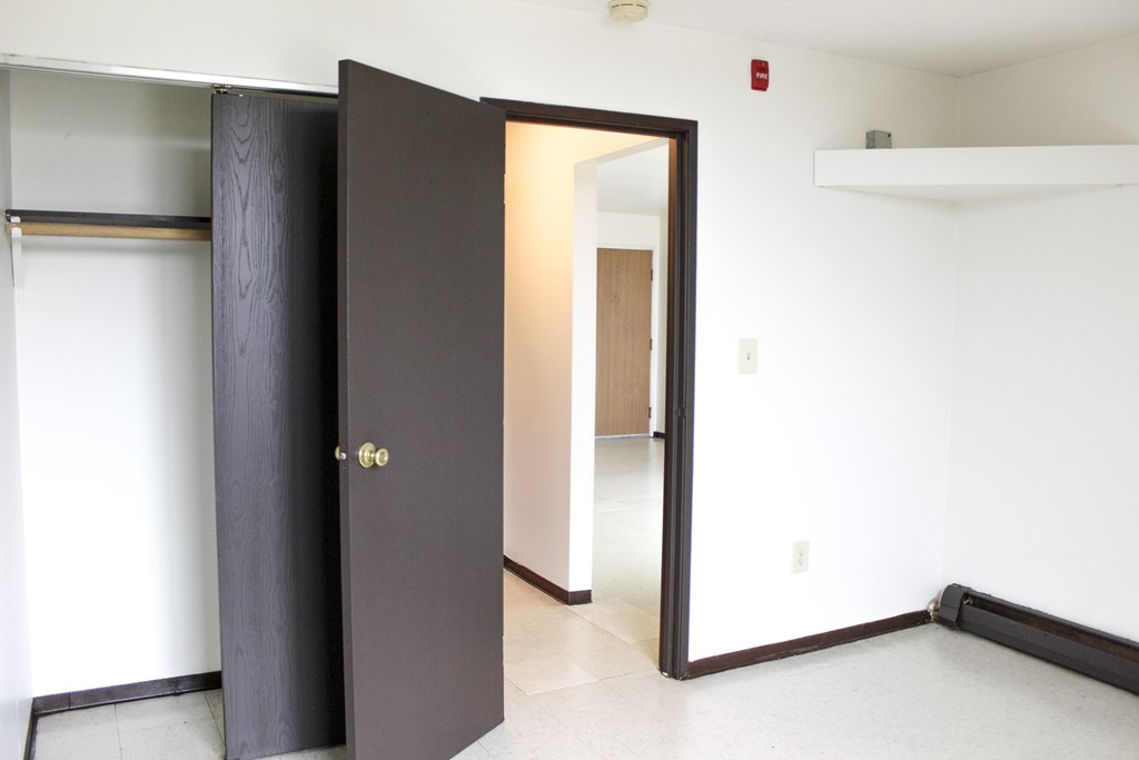 A black door with a gold handle is open.