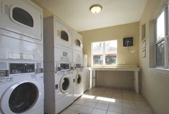 laundry room with washers, dryers, and folding table - Photo Gallery 8