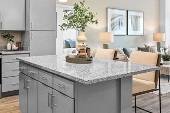 a kitchen with a granite counter top and a living room