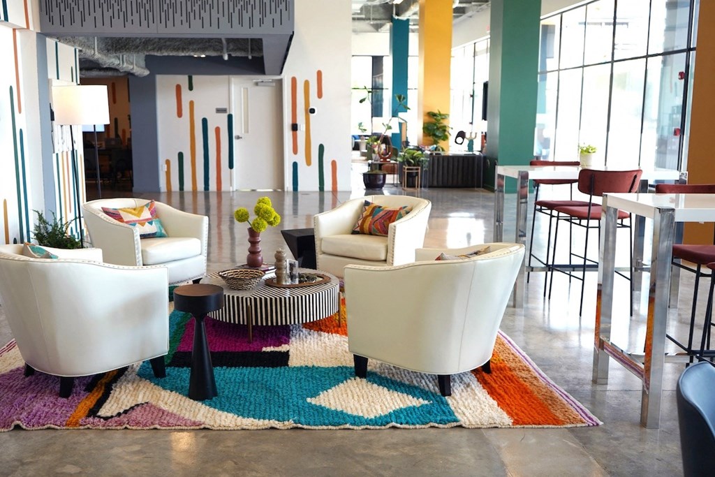 a living room with white furniture and a colorful rug at Citizen Birmingham Apartments