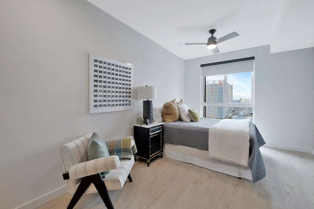 Citizen-Birmingham-View spacious studio with a large city view window, ceiling fan, and wood-style flooring