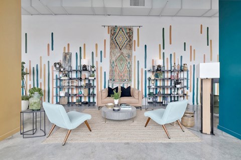 residential lounge on the ground floor with sofa, chairs, mural, and decor