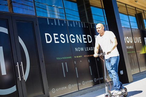a man riding a scooter in front of Citizen Apartments at 300 18th St. S Birmingham, AL 35233