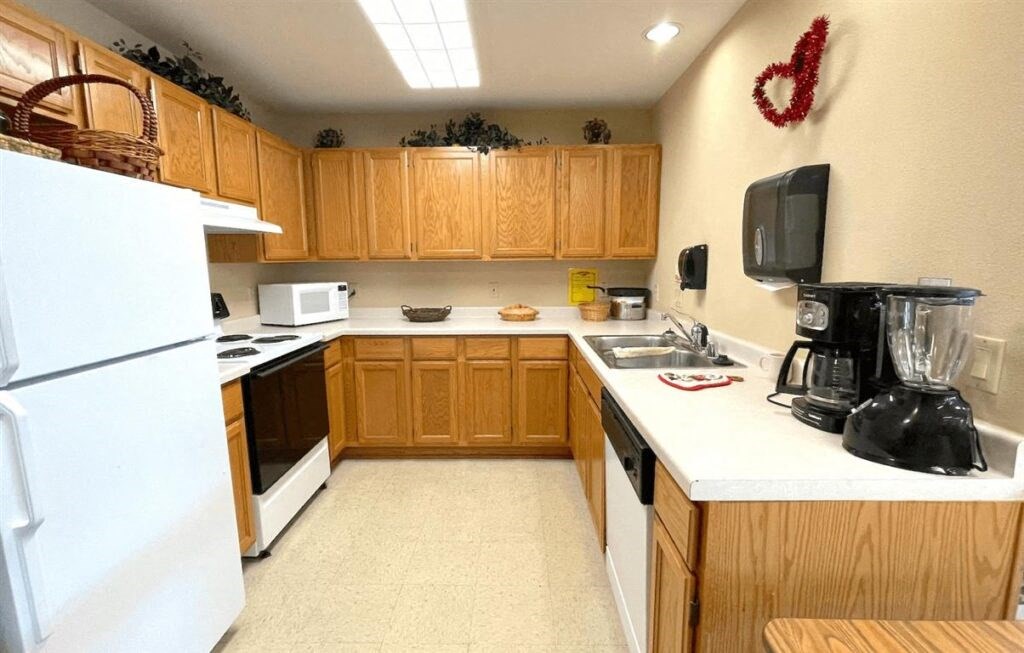 a kitchen at Algonquin Manor with white appliances and wood cabinetry