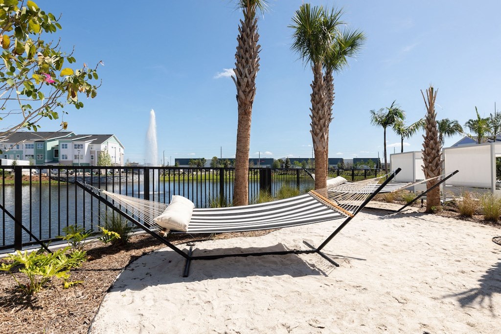 hammocks over sandy area beside Lake Nona Concorde's fenced pond