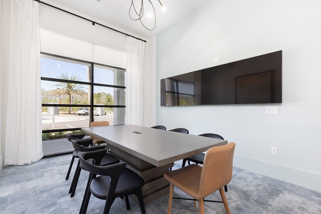 The conference room with tvs, large table, and large window at Concorde