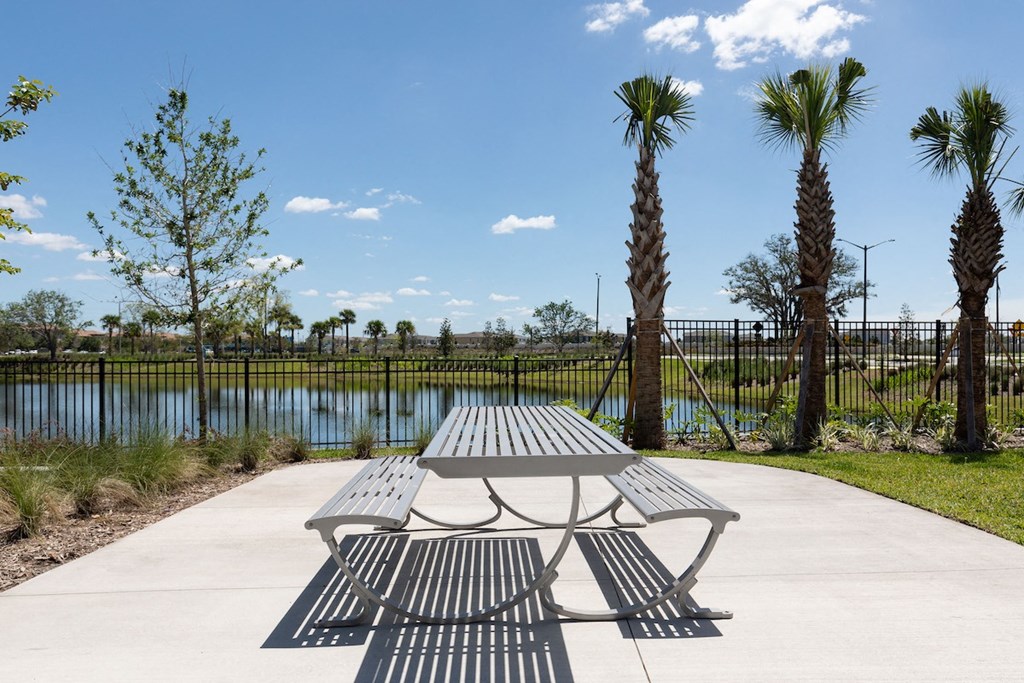 a picnic table near palm trees and the pond at Lake Nona Concorde