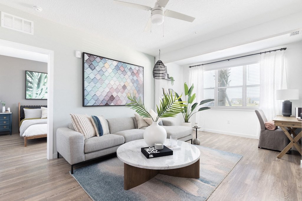 spacious living room with ceiling fan, wood-style floors, and model furnishings