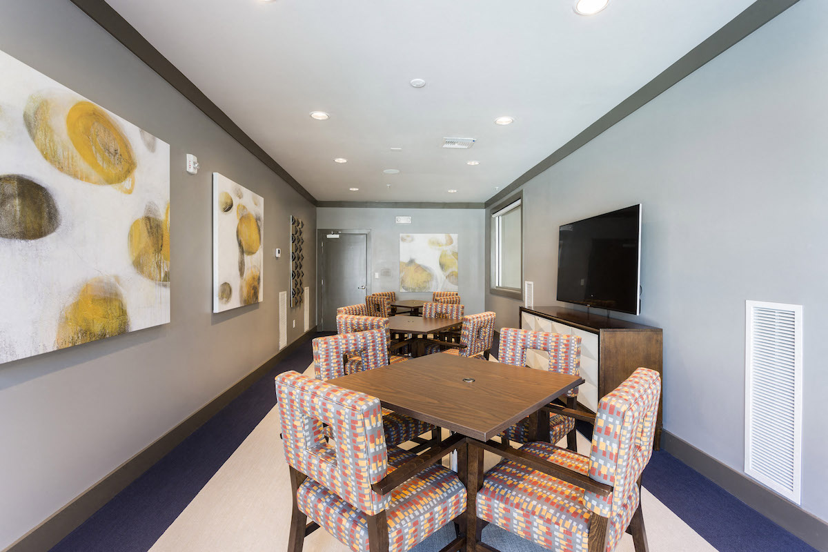 Conference room with tables chairs and tv  at LandonHouse in Lake Nona