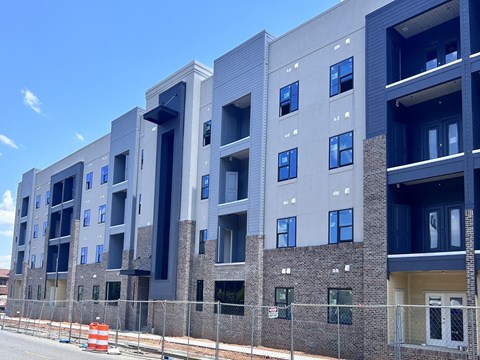 a new apartment building with a fence in front of it
