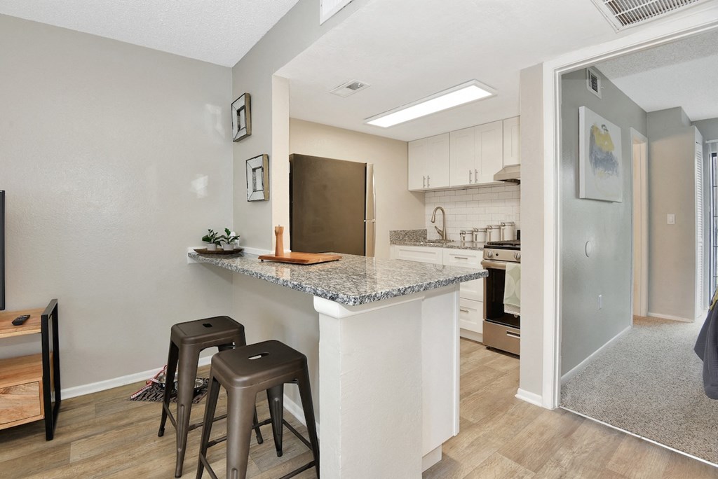 a breakfast bar with stools in the model home at The Oasis Apartments in Daytona Beach, FL