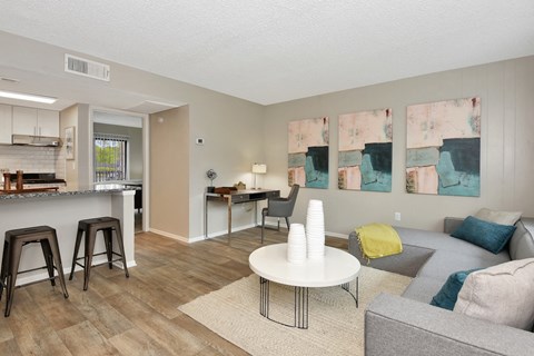 a living room with a couch a table and a kitchen in the background at The Oasis Daytona