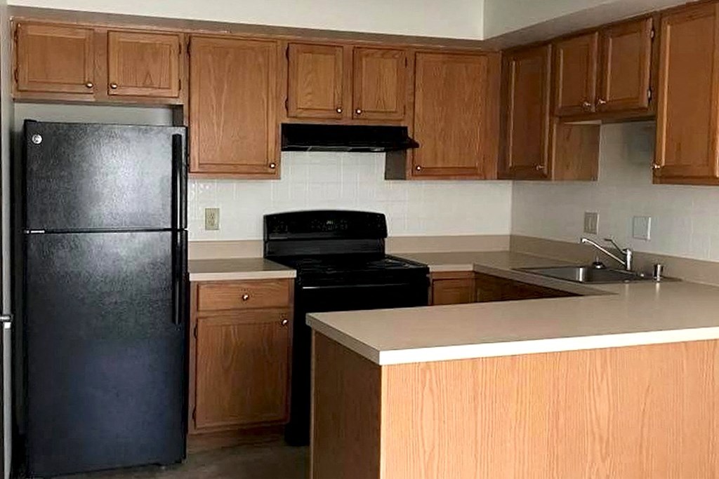 Eastland-Evansville-PG-2 a kitchen with wooden cabinets and a black appliances