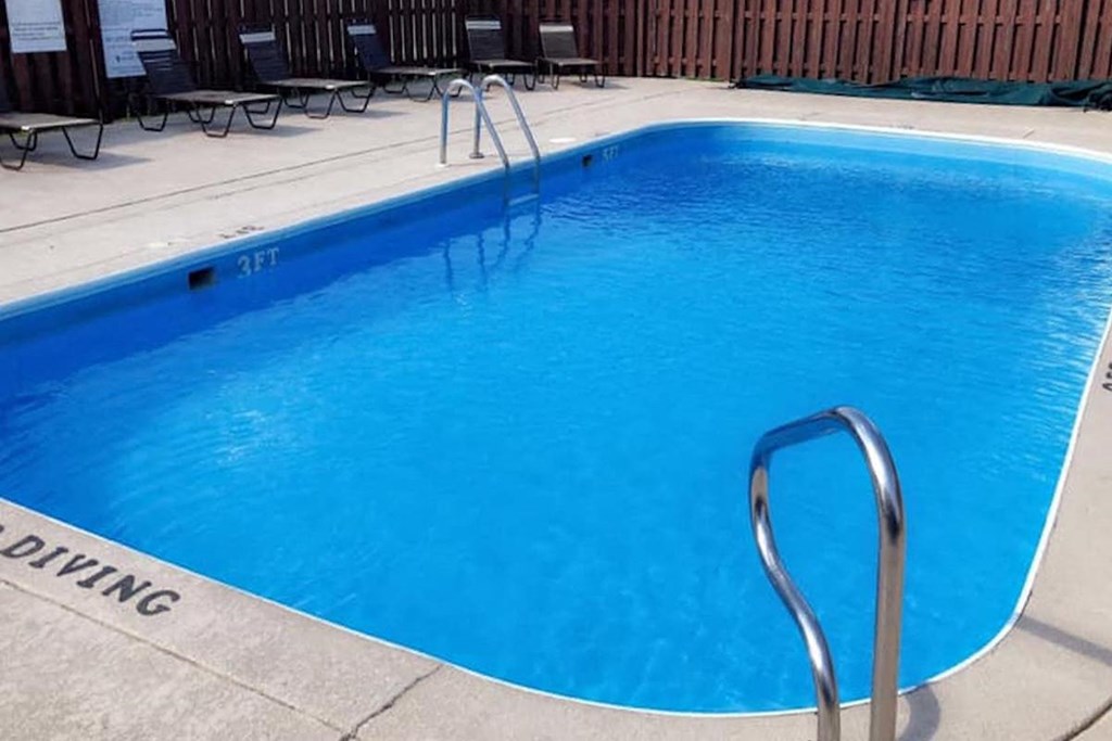 Eastland-Evansville-PG-3 a large, blue swimming pool and a sundeck with lounge chairs