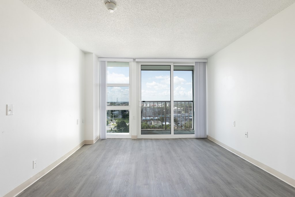 A room with a sliding glass door leading to a balcony.