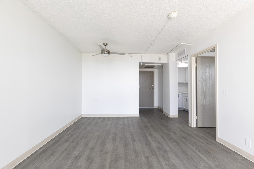 A room with a ceiling fan and a doorway leading to another room.