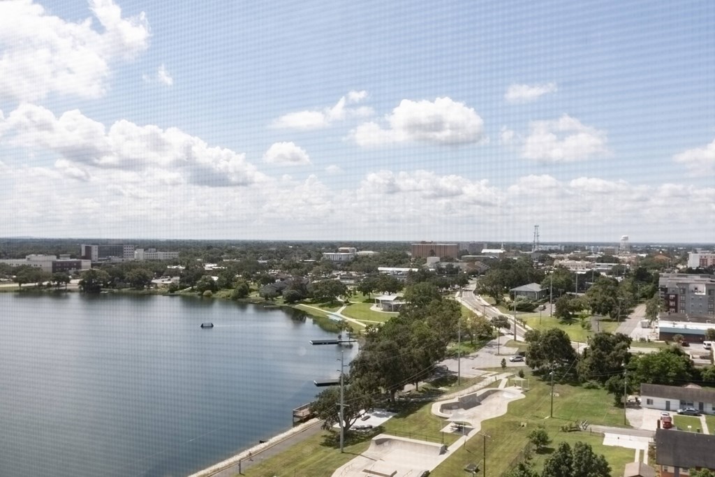 A view of a lake with a boat and a bridge in the distance.