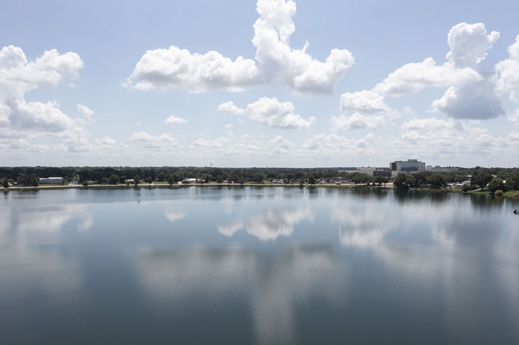 A serene lake with a clear reflection of the sky and clouds.