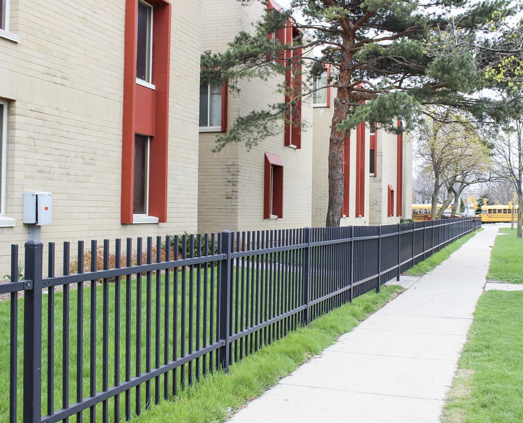 A black metal fence runs along the side of a building.
