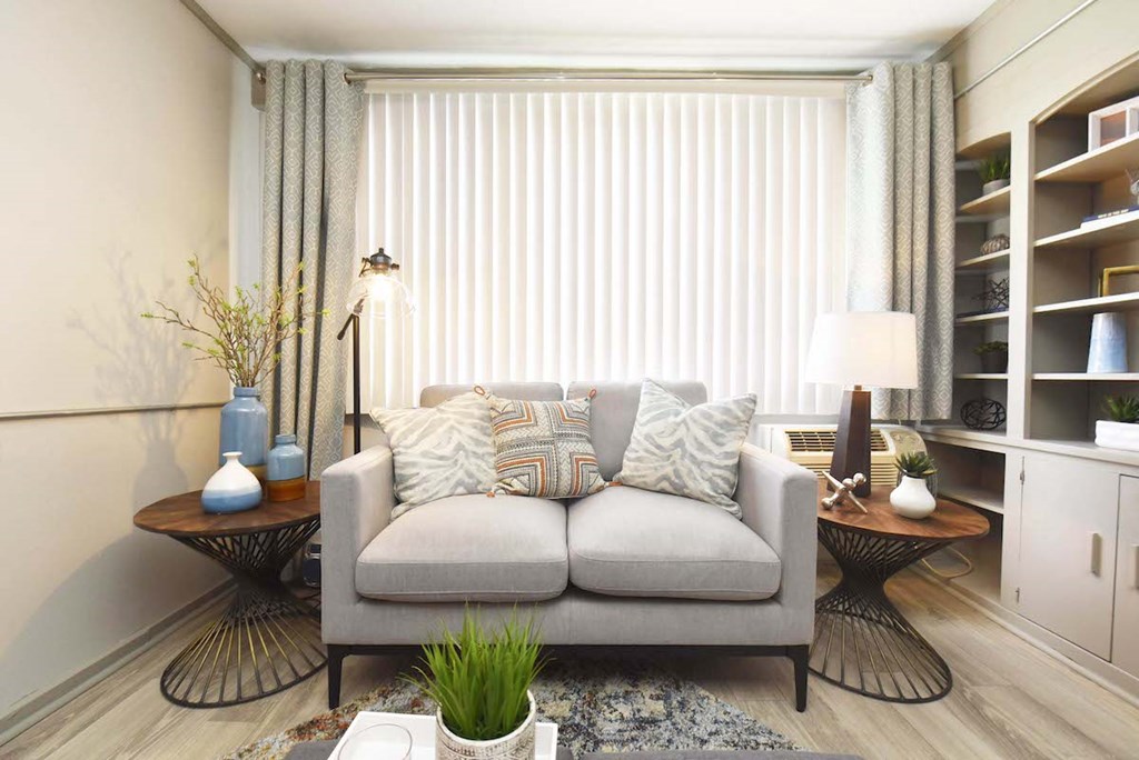 living room with large window, wood-style flooring, and built-in shelving