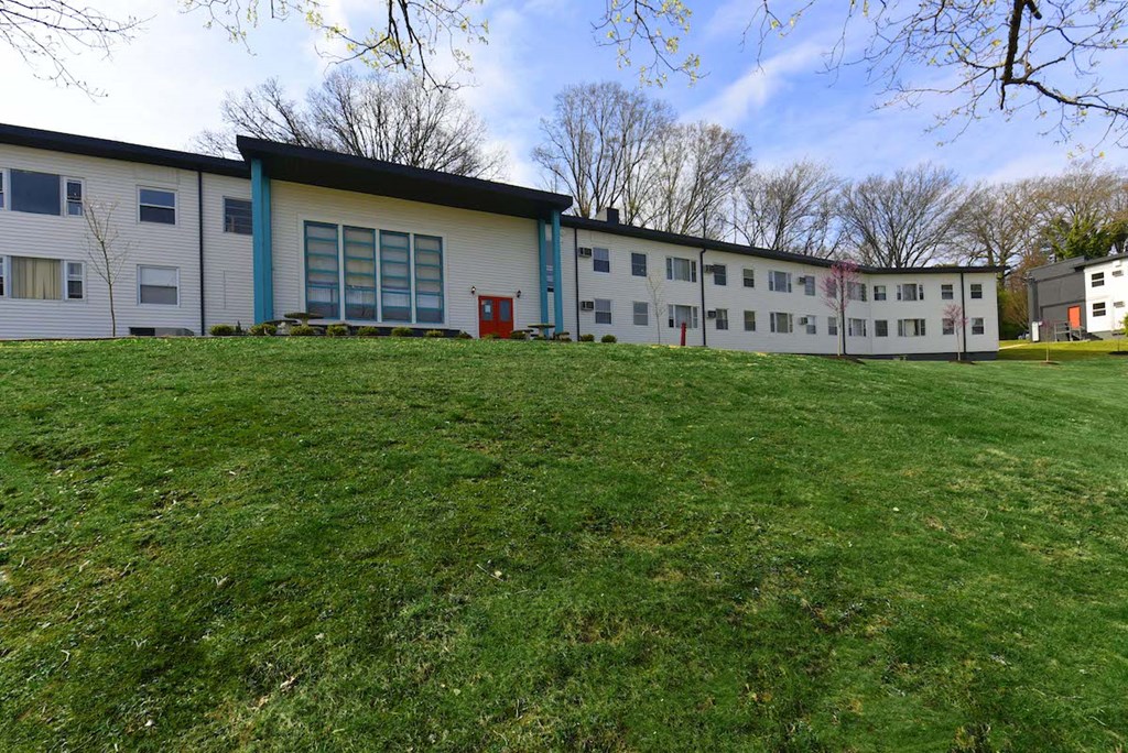 Lush green lawn and mature trees outside of The Flats at Jackson Square