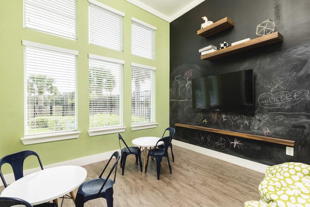 fitness center child room with tables chairs and blackboard
