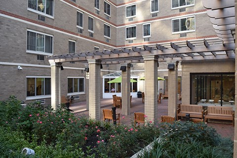 a courtyard with benches and tables in front of a building