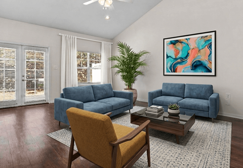 A living room with a blue couch, a yellow chair, and a painting on the wall.