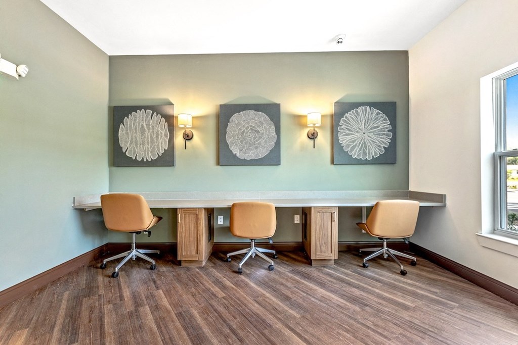 a conference room with a long table and chairs and paintings on the wall