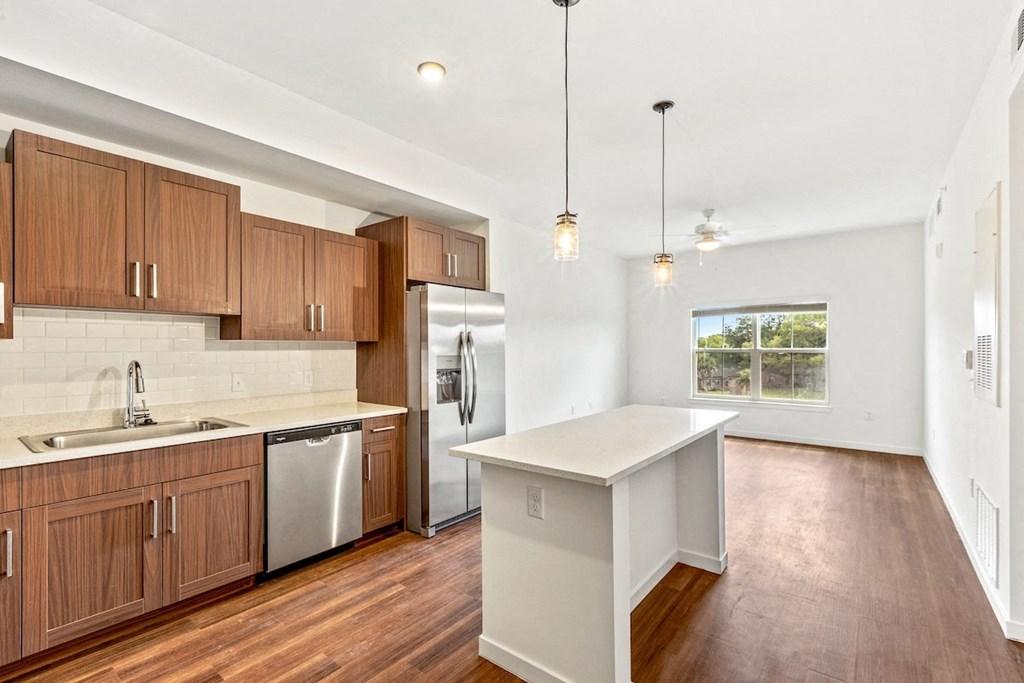 a kitchen with wooden cabinets and stainless steel appliances and a white counter top