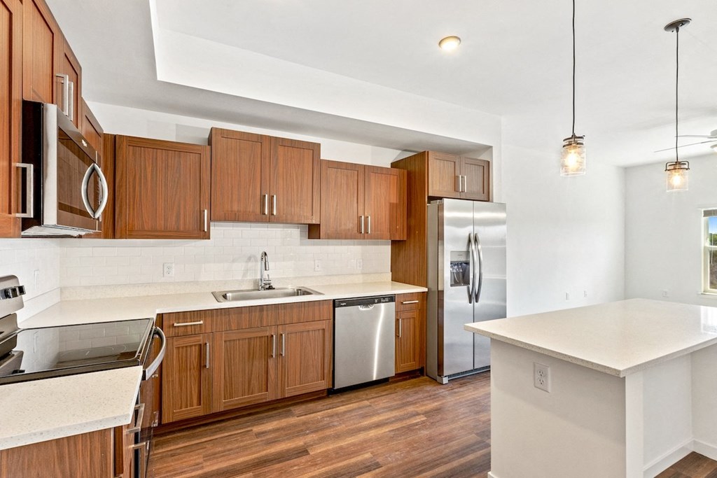 a kitchen with wooden cabinets and a stainless steel refrigerator