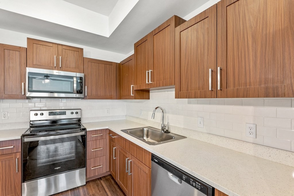 a kitchen with wooden cabinets and a sink and a stove