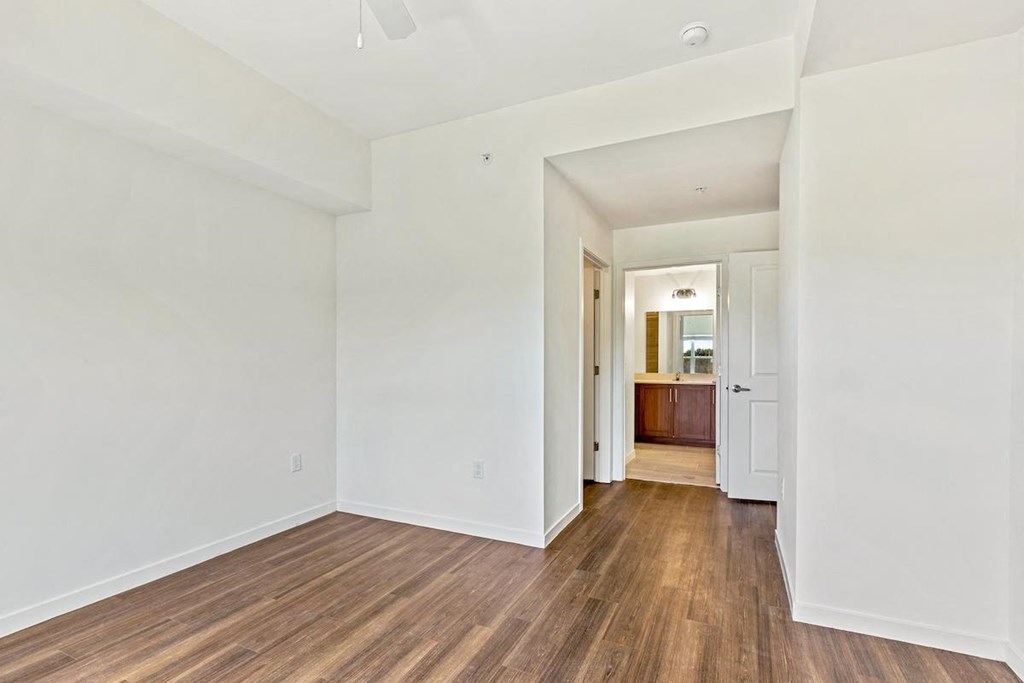 a living room with white walls and wood floors