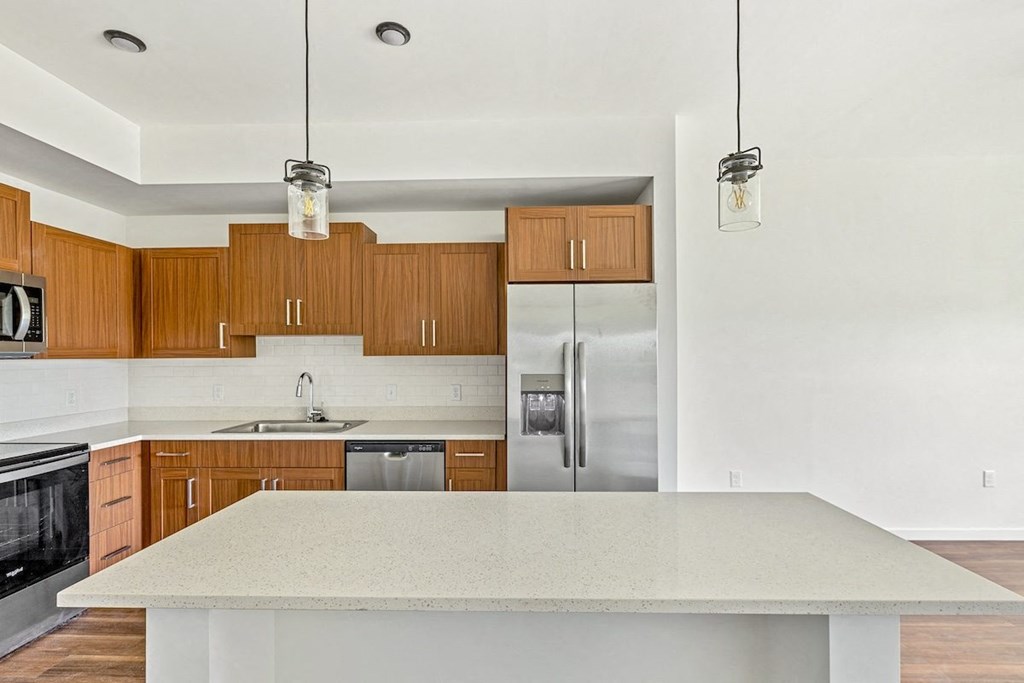 a kitchen with a large island and a stainless steel refrigerator