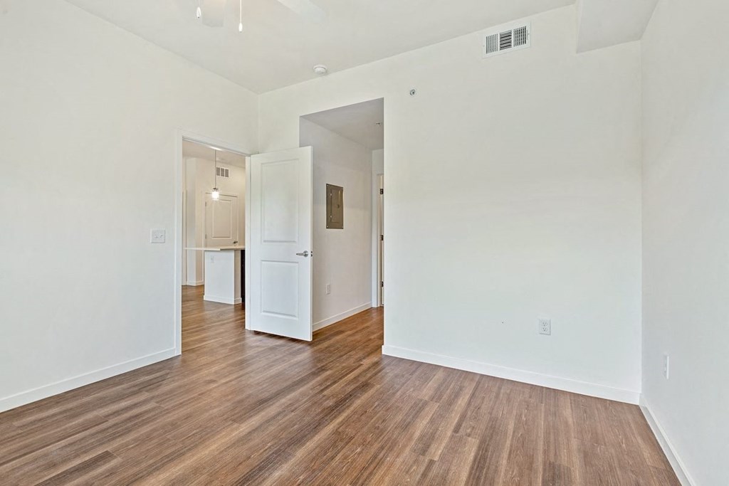 a living room with white walls and wood floors