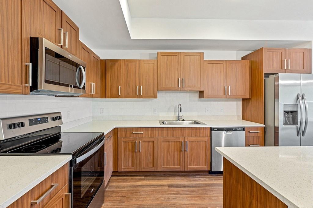 a kitchen with wooden cabinets and stainless steel appliances