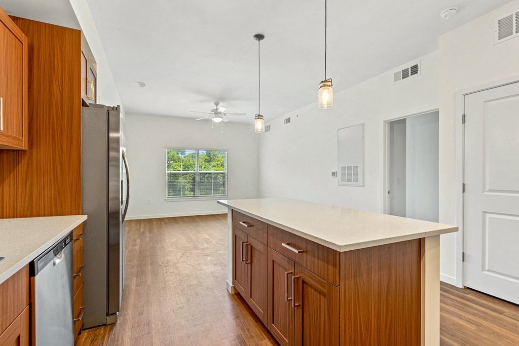 a kitchen with an island and a stainless steel refrigerator