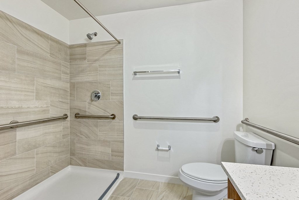 a bathroom with a toilet and a shower and a sink