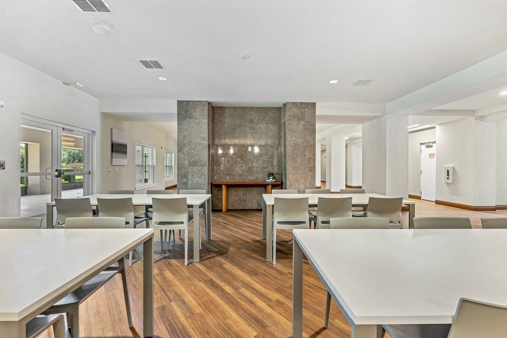 a dining room with tables and chairs and a kitchen