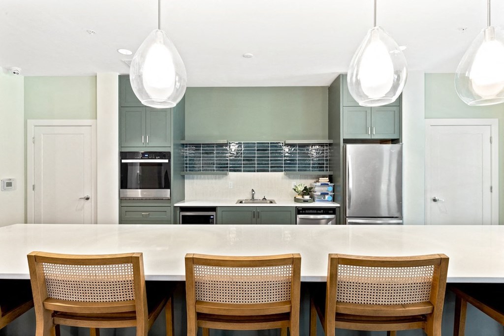 a modern kitchen with a large island with wooden chairs