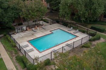 Hampton-House-Pool-3 Fenced pool and sundeck surrounded by lush trees at Hampton House Apartments