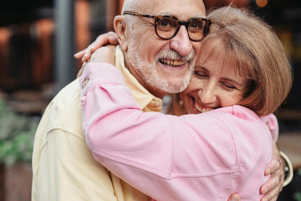 a older man and a woman hugging each other