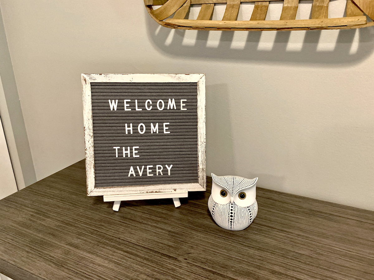 a table with a sign that says welcome home the avery and two owls on it