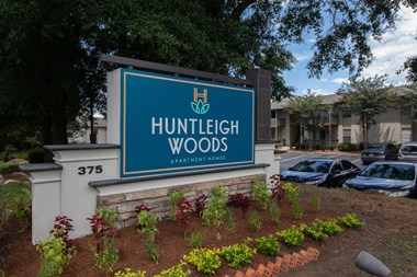 Monument Sign at entrance to community stating Huntleigh Woods