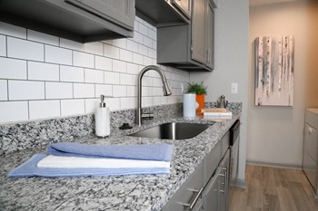 PG6 sleek granite countertops in kitchen surrounding stainless steel sink - Photo Gallery 2