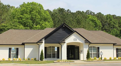 A white building with a black roof and a sign on the front.